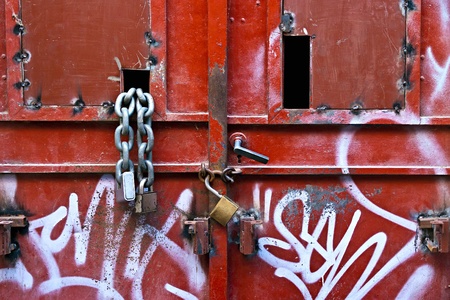 Metal padlocks and chain on metal door