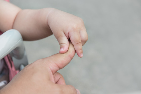 Baby hands hold father finger.の写真素材