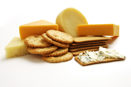 A collection a various types of cheeses and cracker biscuits on an isolated white studioの写真素材