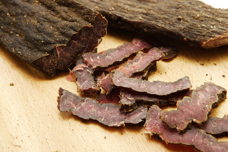 A closeup of traditional south african biltong on a wooden chopping boardの写真素材