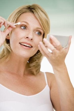 Woman putting on eye make upの写真素材