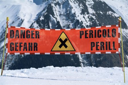 Danger sign on snowy mountain (selective focus)の写真素材