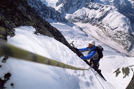 Mountain climber going up snowy mountain