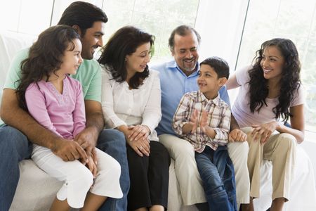Family sitting in living room smiling (high key)の写真素材