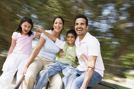 Family outdoors in playground spinning and smiling (blur)