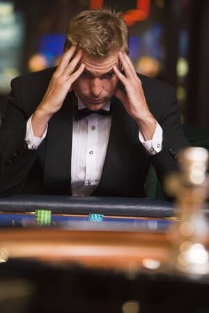 Man in casino playing roulette and losing (selective focus)の写真素材