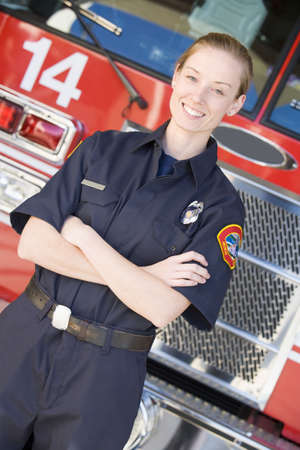Firewoman standing in front of fire engineの写真素材
