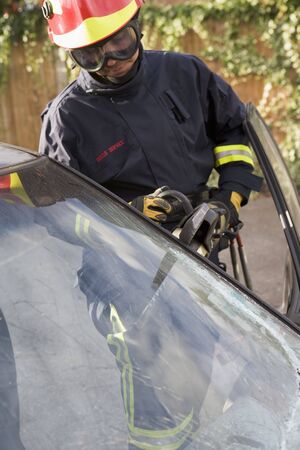 Firefighter cutting out a windshield after an accidentの写真素材