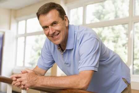 Teacher in corridor leaning on railingの写真素材