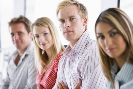 Four businesspeople sitting indoors smiling