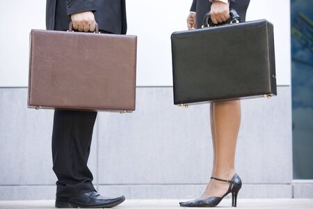 Two businesspeople holding briefcases outdoorsの写真素材