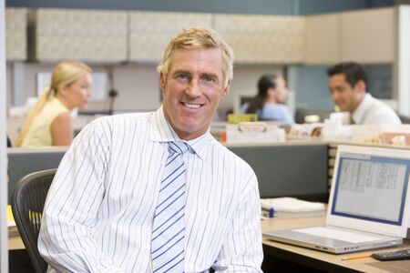 Businessman in cubicle smiling