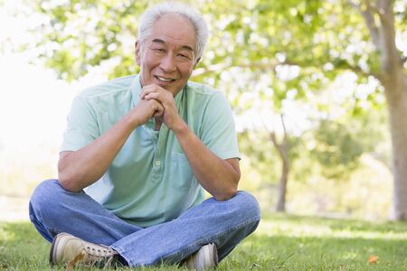 Man sitting outdoors smilingの写真素材
