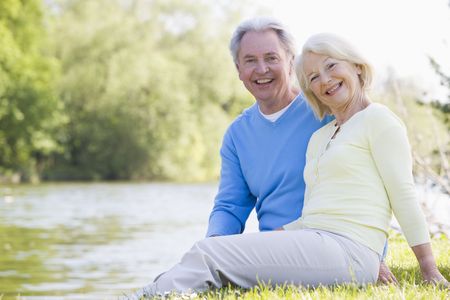 Couple outdoors at park by lake smilingの写真素材
