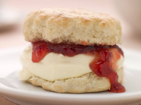Scone Filled with Strawberry Jam and Clotted Cream on a plateの写真素材