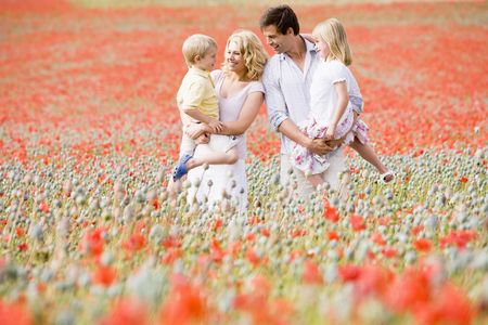 Family standing in poppy field smilingの写真素材