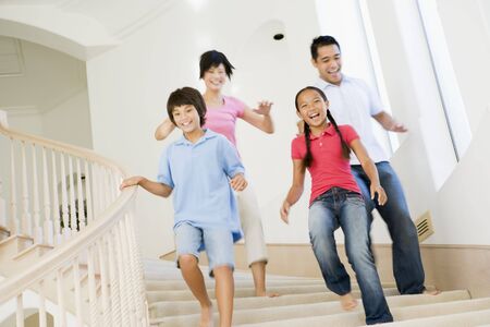 Family running down staircase smilingの写真素材