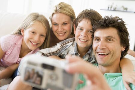 Family taking self portrait with digital cameraの写真素材