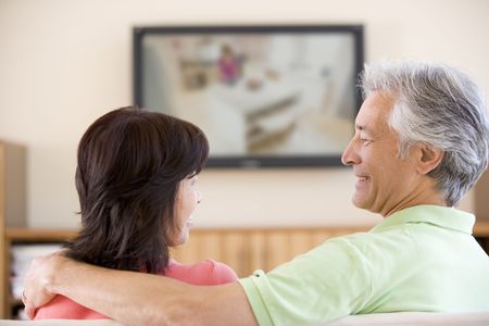 Couple watching television smilingの写真素材