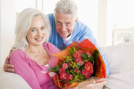 Husband and wife holding flowers and smilingの写真素材