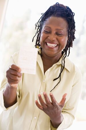 Woman with winning lottery ticket excited and smilingの写真素材