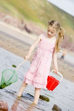 Young girl at beach with net and pailの写真素材