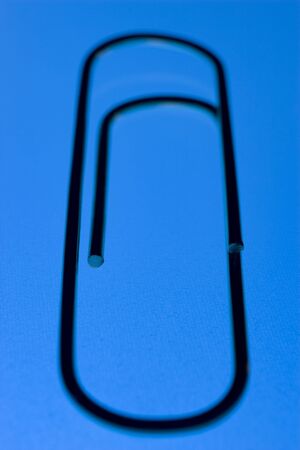 Close Up Of A Blue Paperclip, Against A Blue Backgroundの写真素材