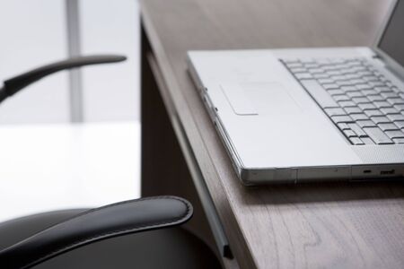 Empty Chair And Desk With Laptop Computerの写真素材