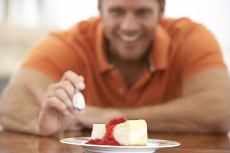 Middle Aged Man Eating Cheesecakeの写真素材