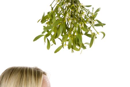 Woman Standing Under Bunch Of Mistletoe Against White Backgroundの写真素材