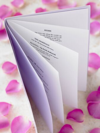 Wedding Booklet Surrounded By Rose Petalsの写真素材