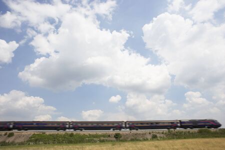 Passenger Train Moving Beneath A Clouded Skyの写真素材