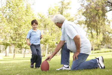 Grandfather And Grandson Playing American Football Togetherの写真素材