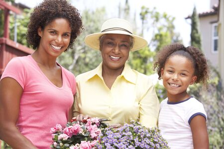 Senior Woman With Adult Daughter And Granddaughter Gardening Together