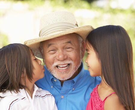 Grandfather With Granddaughters In Gardenの写真素材