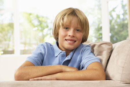 Young Boy Relaxing On Sofa At Home