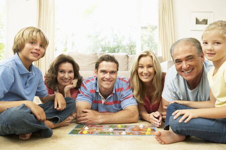 Family Playing Board Game At Home With Grandparents Watching