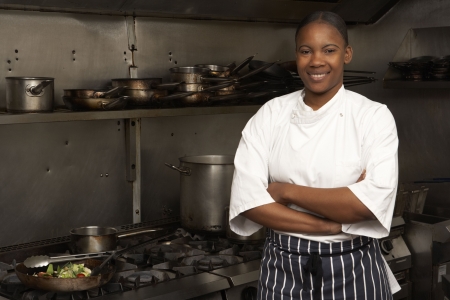 Female Chef Standing Next To Cooker In Restaurant Kitchenの写真素材