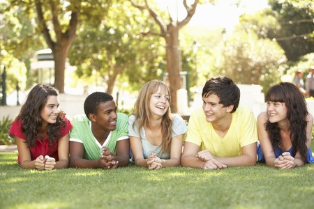 Group Of Teenagers Lying On Stomachs In Park