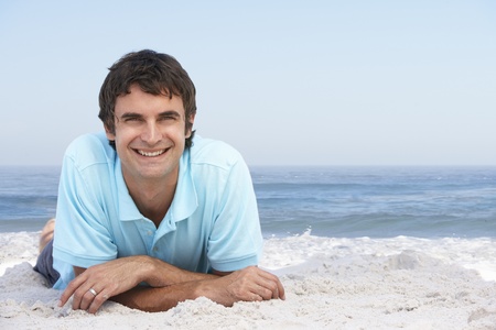Young Man Relaxing On Sandy Beachの写真素材