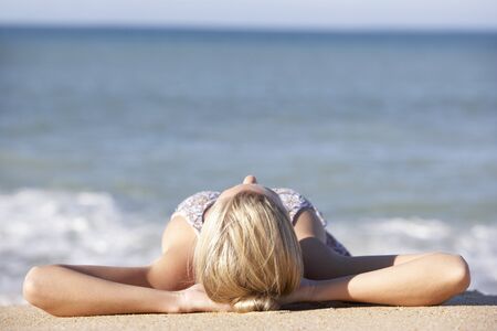Young Woman Sunbathing On Beachの写真素材