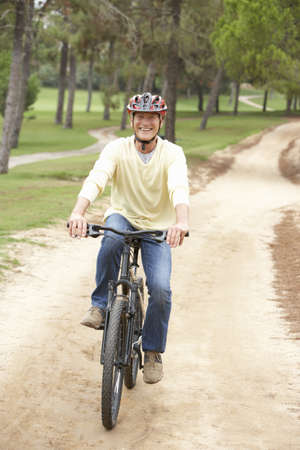 Senior man riding bicycle in park