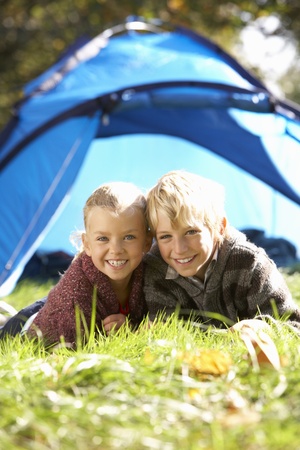 Young children pose outside of tentの写真素材