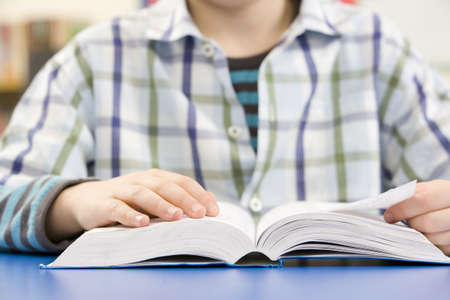 Close Up Of Schoolboy Studying Textbook In Classroomの写真素材
