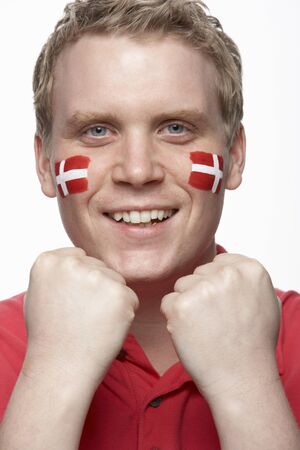 Young Male Sports Fan With Danish Flag Painted On Faceの写真素材