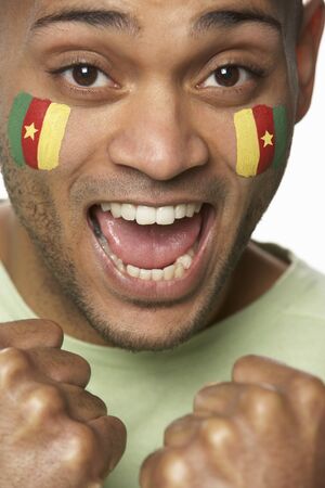 Young Male Sports Fan With Cameroon Flag Painted On Faceの写真素材