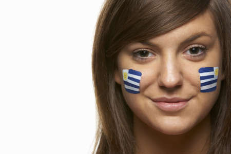 Young Female Sports Fan With Uruguayan Flag Painted On Faceの写真素材