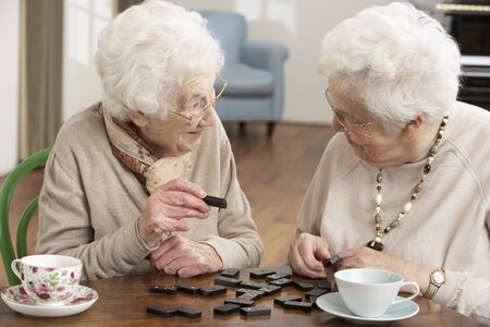 Two Senior Women Playing Dominoes At Day Care Centreの写真素材