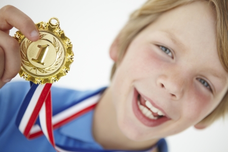 Young boy showing off medalの写真素材