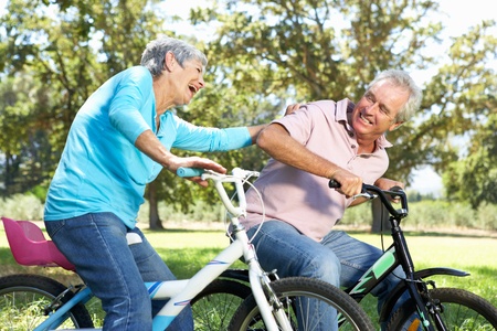 Senior couple playing on children's bikesの写真素材